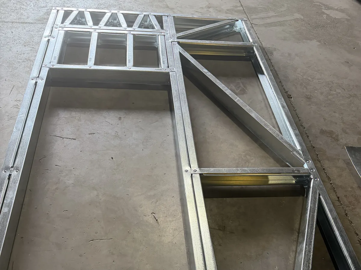 Pre-assembled steel wall panel with a trussed header